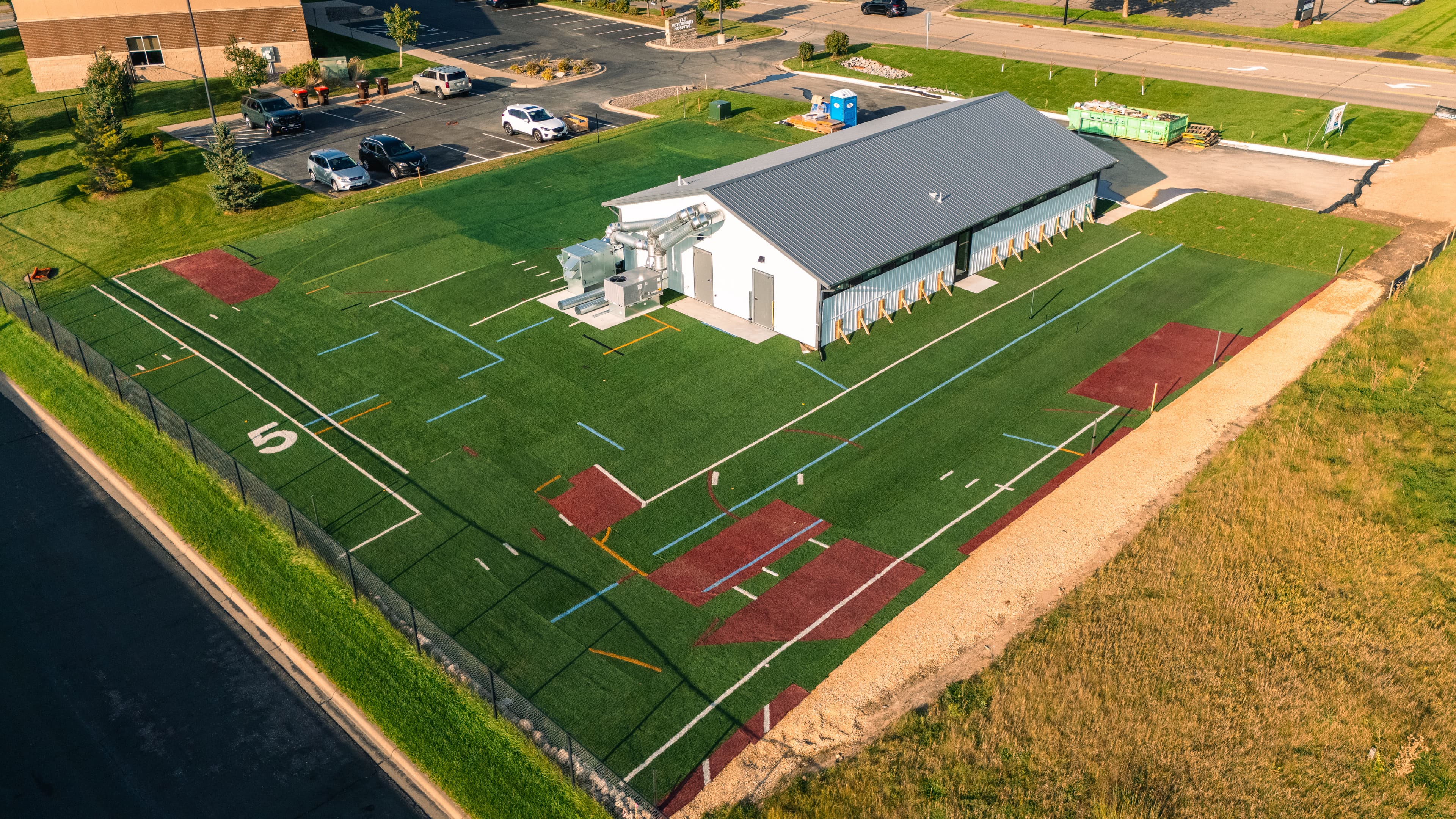 Aerial view of a sports training facility with artificial turf and equipment outdoors.