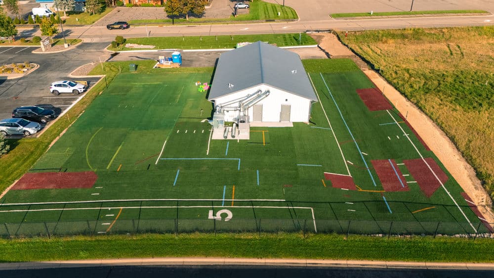 Aerial view of a sports training facility with artificial turf and marked sections for drills.