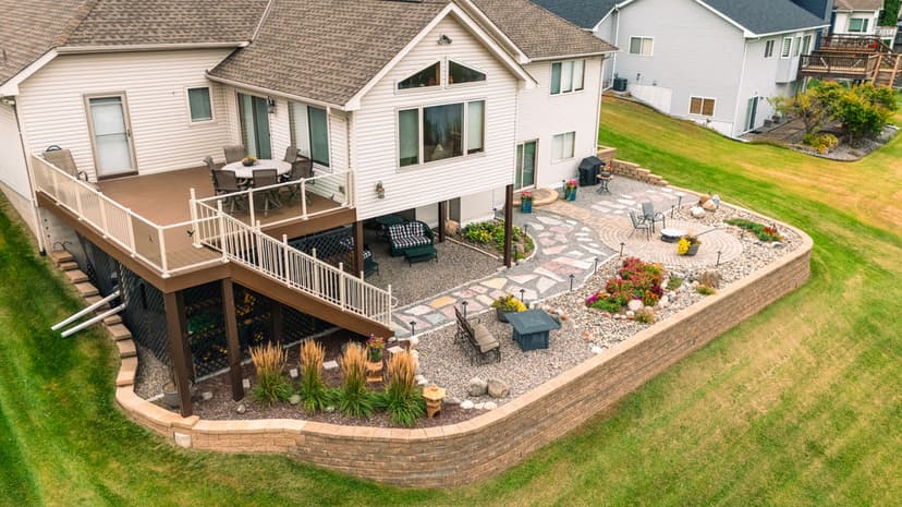 Aerial view of a modern home with landscaped patio and garden in a residential area.