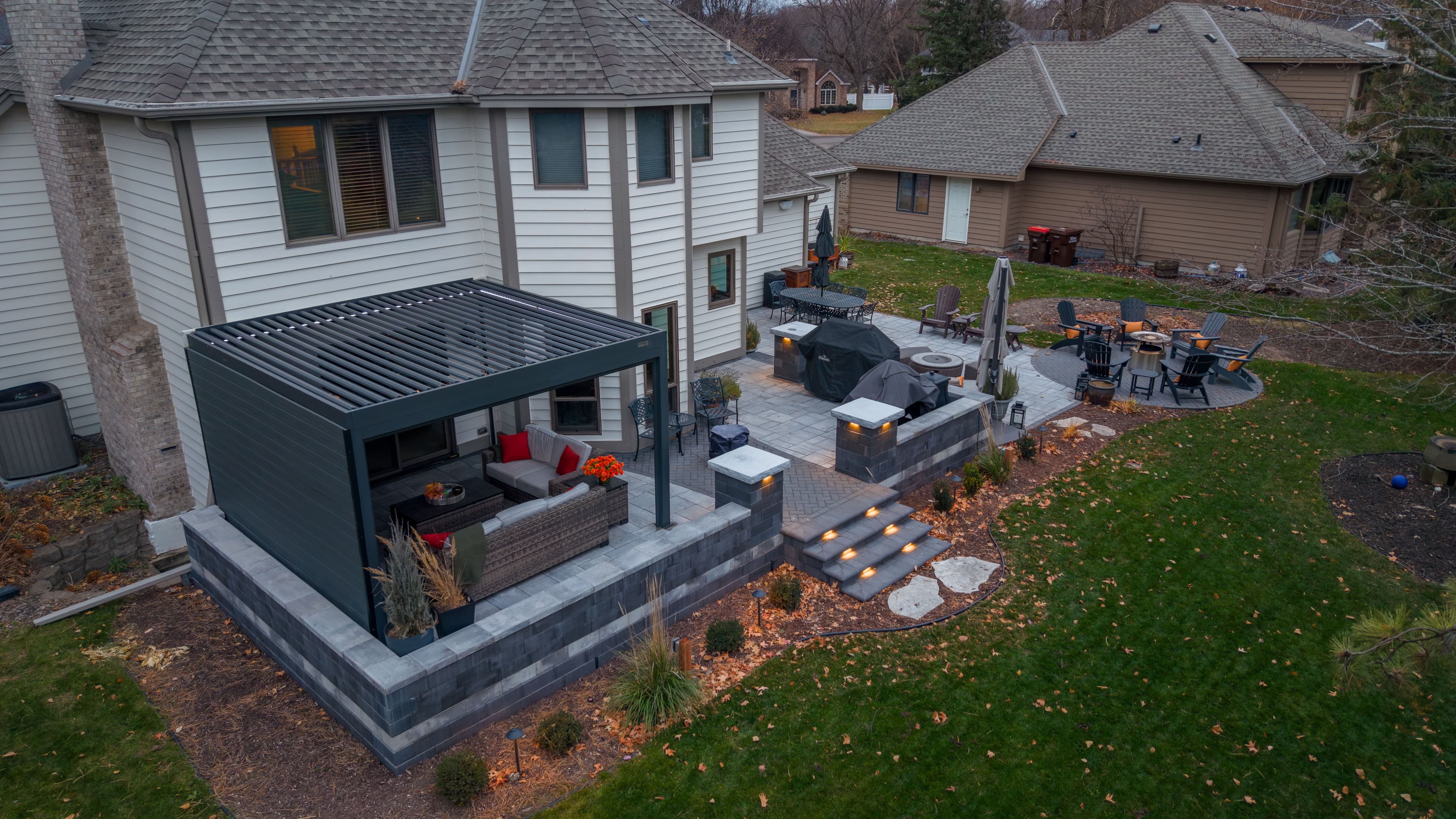 Modern backyard patio with seating, grill area, and landscaped garden. Beautiful outdoor design.